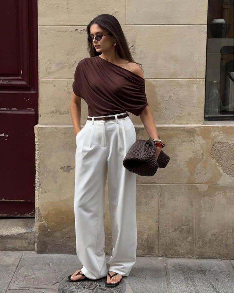 Фигура грушевидной формы, белые свободные брюки, блузка с необычным вырезом.