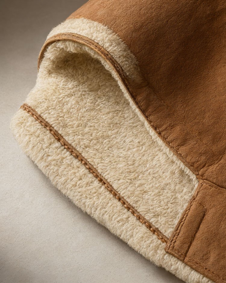 Крупный план дублёнки из shearling с коричневой замшевой и светлой шерстяной сторонами
